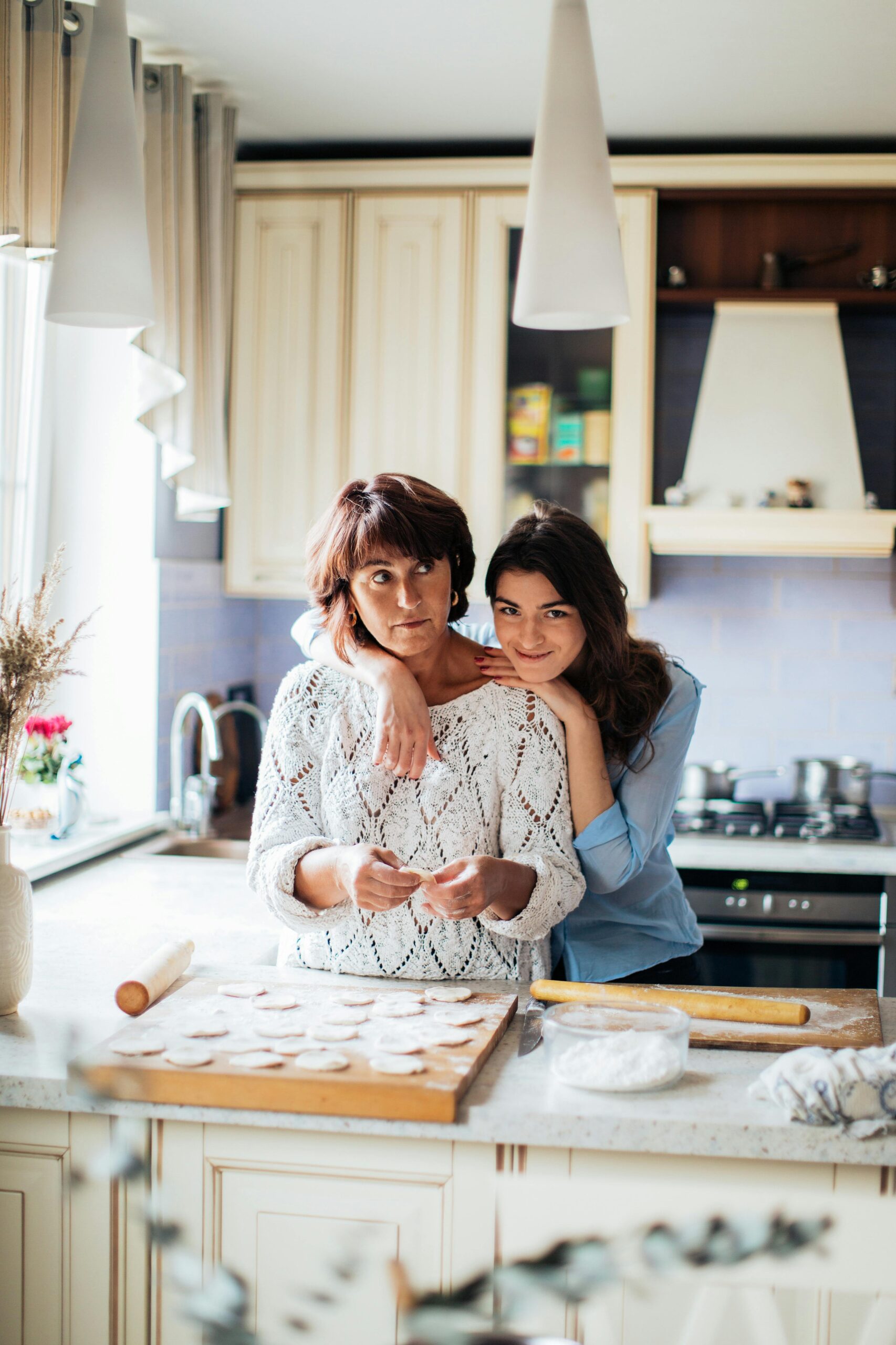 A heartwarming scene of a mother and daughter bonding while baking in their kitchen.