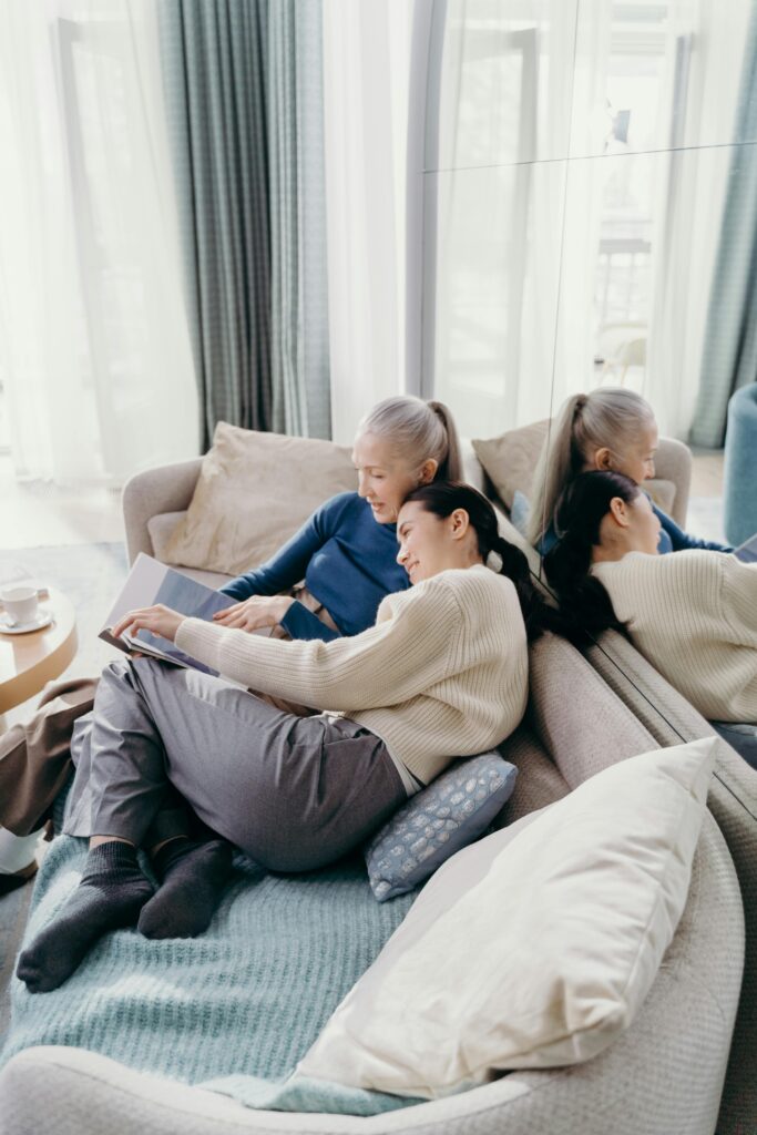 A senior woman and her daughter enjoying a relaxing moment together on a cozy sofa.